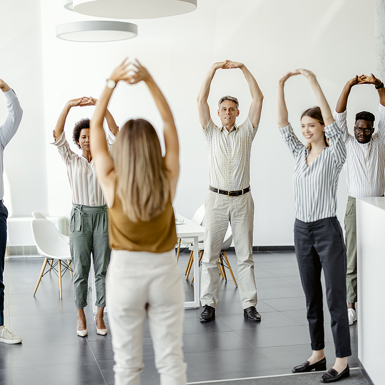 Geschäftsleute, die am Arbeitsplatz Stretching-Übungen machen