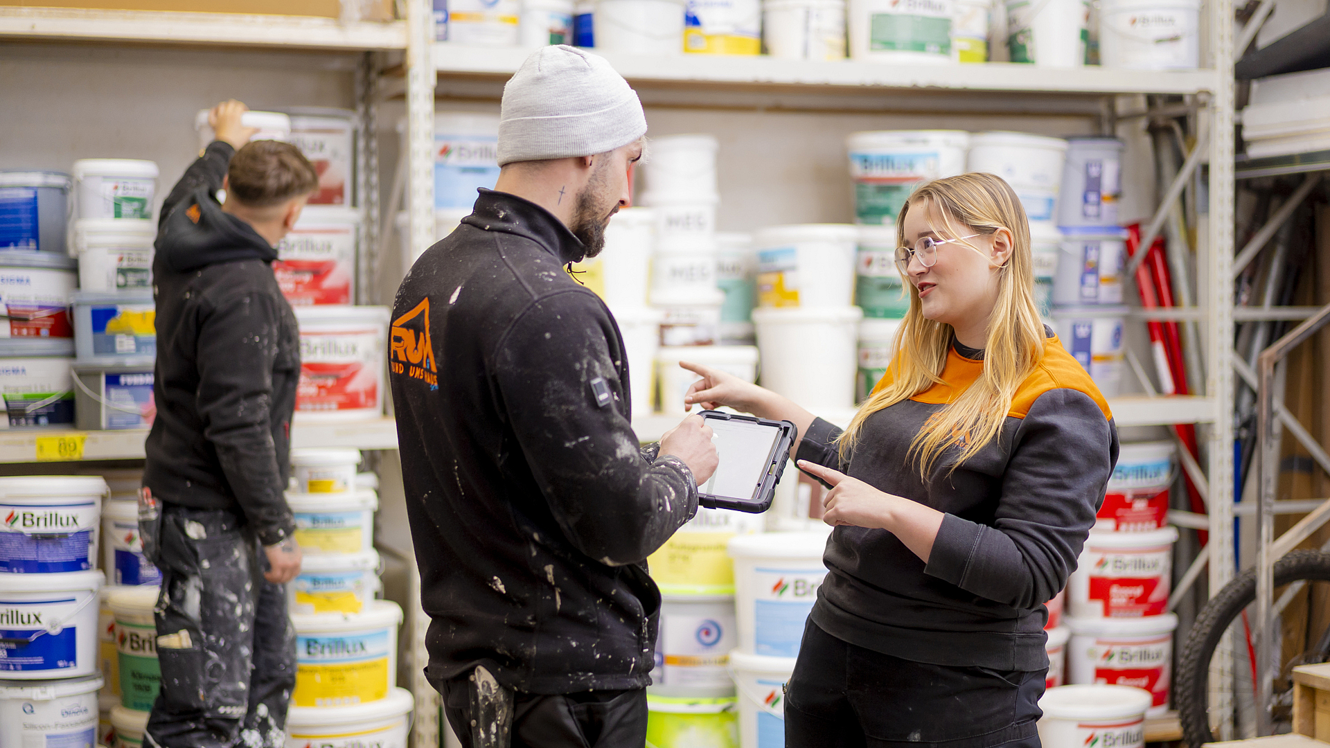 Zwei Mitarbeiter des Malerbetriebs RUH unterhalten sich im Lager