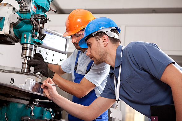 Zwei Männer arbeiten an einer Metallfräse