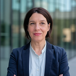 Ältere dunkelhaarige Frau schaut in die Kamera