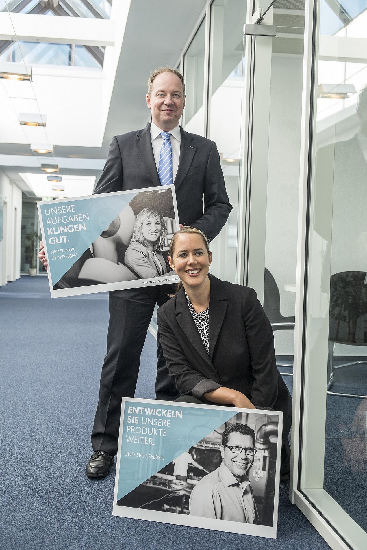 Nina Mohammadi und Thomas Sundermann zeigen zwei Plakate der Kampagne.
