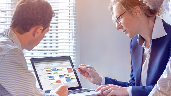 Zwei Personen blicken auf einen Terminkalender.