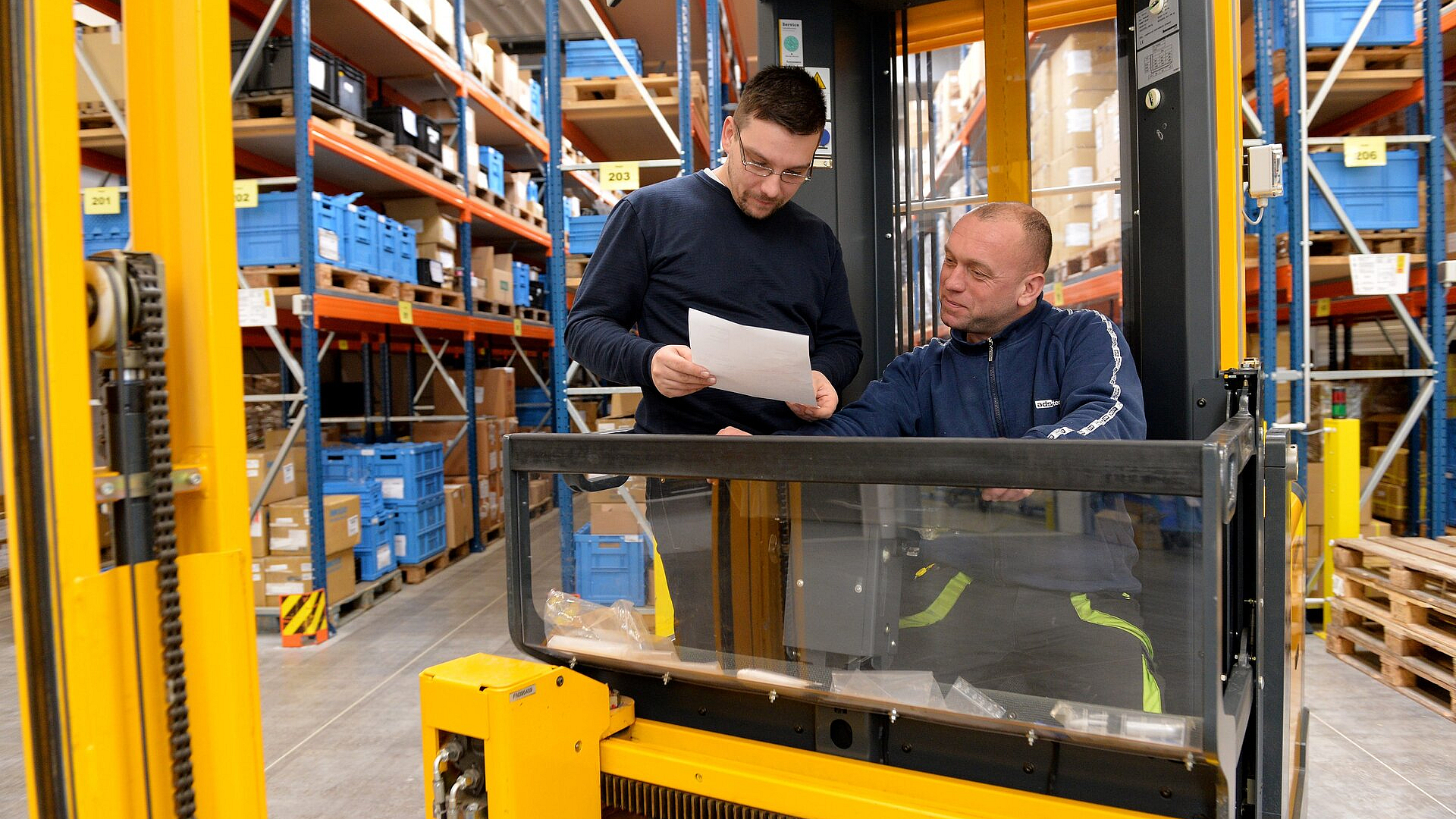 David Sattler mit einem Kollegen bei einer kurzen Besprechung am Gabelstapler.