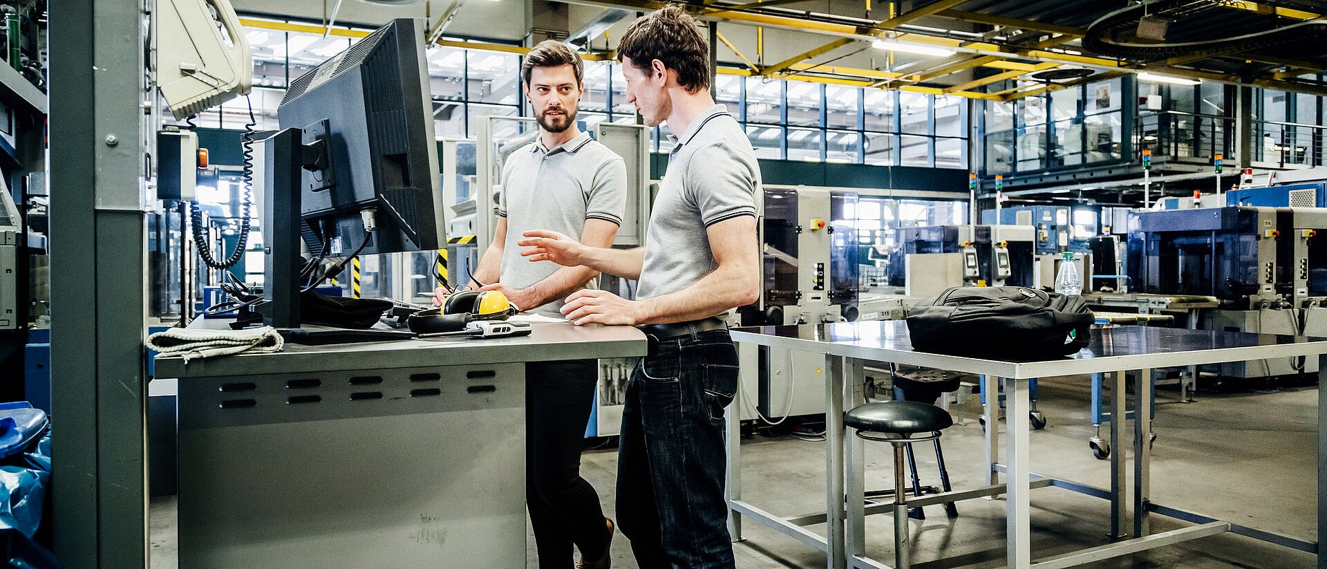 Zwei Ingenieure unterhalten sich in einer Produktionshalle