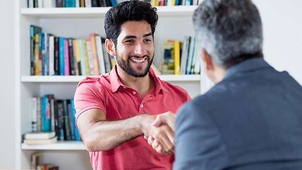 © DMEPhotography - istock.com Junger Mann und älterer Mann geben sich die Hand