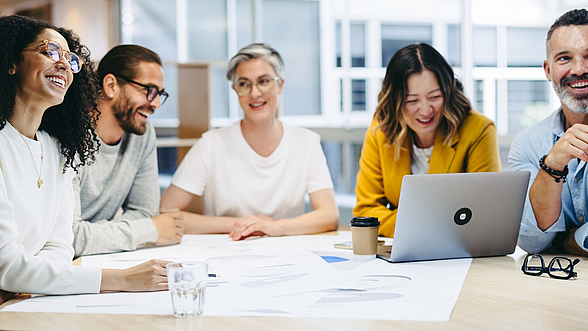 Eine Gruppe von Personen tauscht sich an einem Tisch aus.
