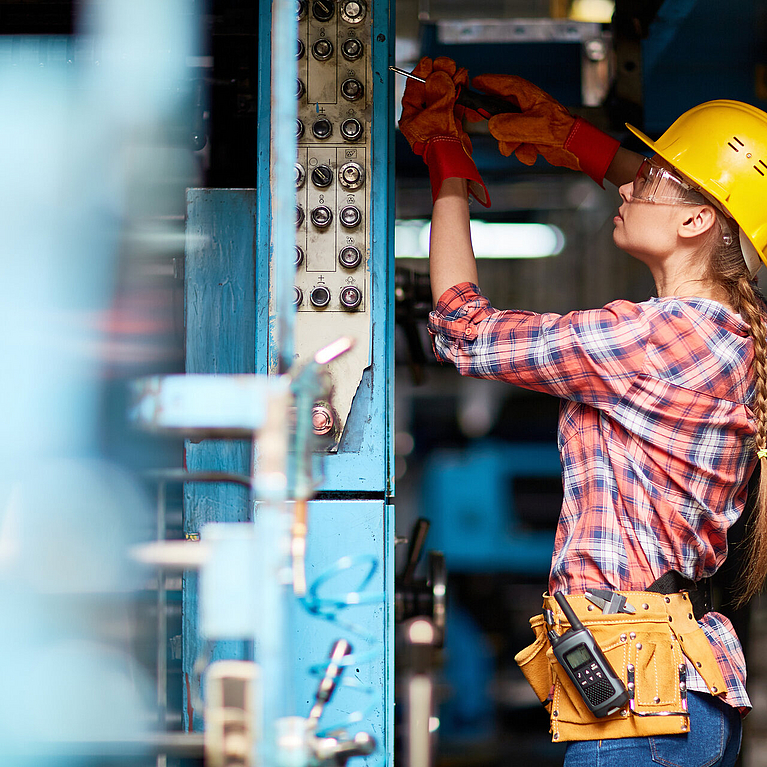 Technikerin arbeitet in einer Werkshalle