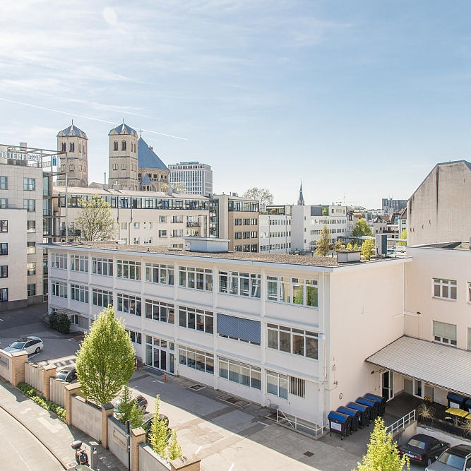Luftperspektive auf das Headquarter der Klosterfrau Group in Köln. Im Hintergrund sind der Kölner Fernsehturm und die Türme der Basilika St. Aposteln zu sehen.