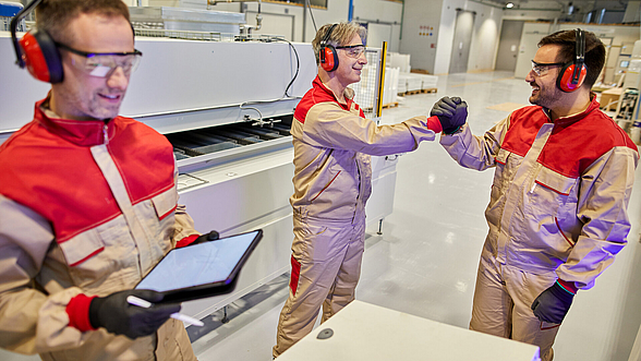 Drei Männer in Arbeitskleidung und gemeinsamer Arbeit