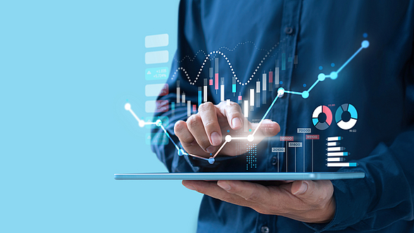 Eine Person hat ein Tablet in der Hand, auf dem Tablet ist eine digitale Grafik zu sehen 