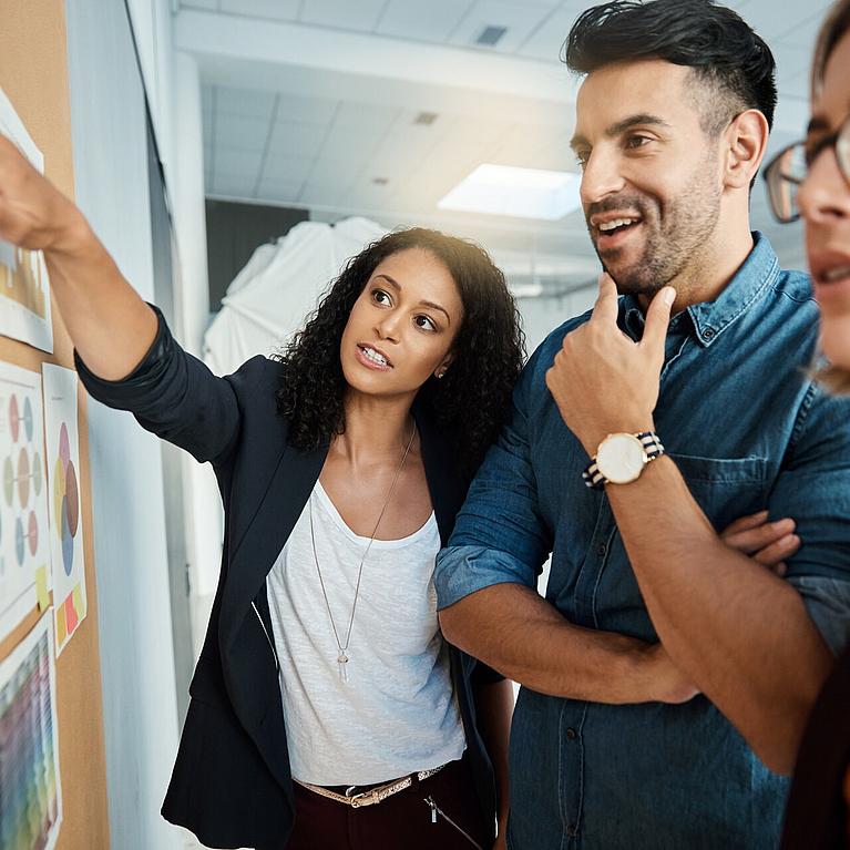 Junge Leute stehen vor einem Whiteboard