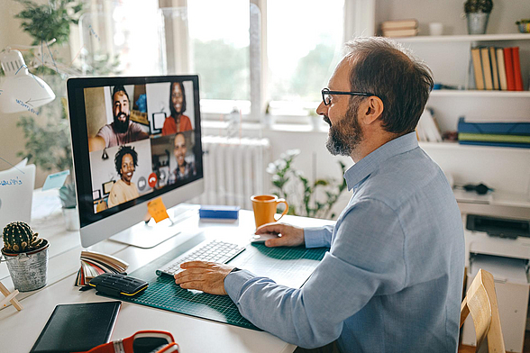 Ein Mann nimmt im Homeoffice an einer Video-Konferenz teil