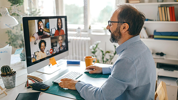 Ein Mann nimmt im Homeoffice an einer Video-Konferenz teil
