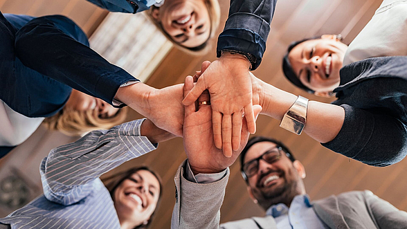 Personen legen die Hände aufeinander