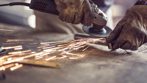 © skynesher – istock.com Ein Mann arbeitet mit einem Schleifgerät