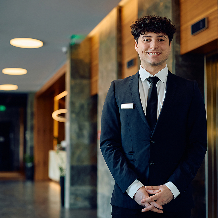 Junger Auszubildende mit Migrationshintergrund im Foyer eines Hotels