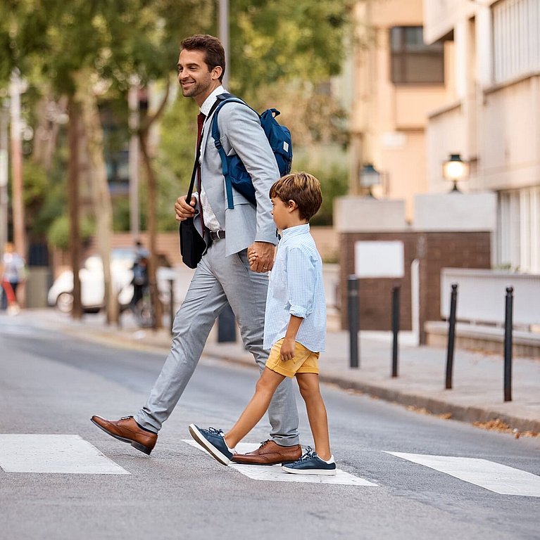 Vater und Sohn überqueren die Straße