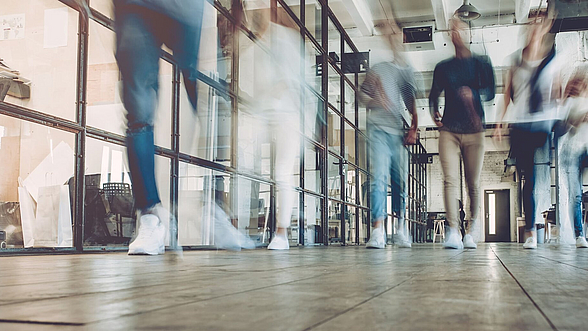 Menschen laufen einen Flur entlang