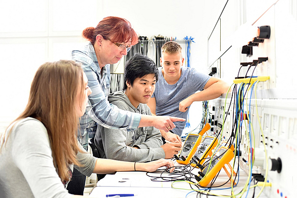 Gruppe von Jugendlichen in der technischen Berufsausbildung mit Lehrerin