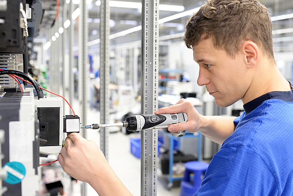 Mann in Industriehalle mit Werkzeug