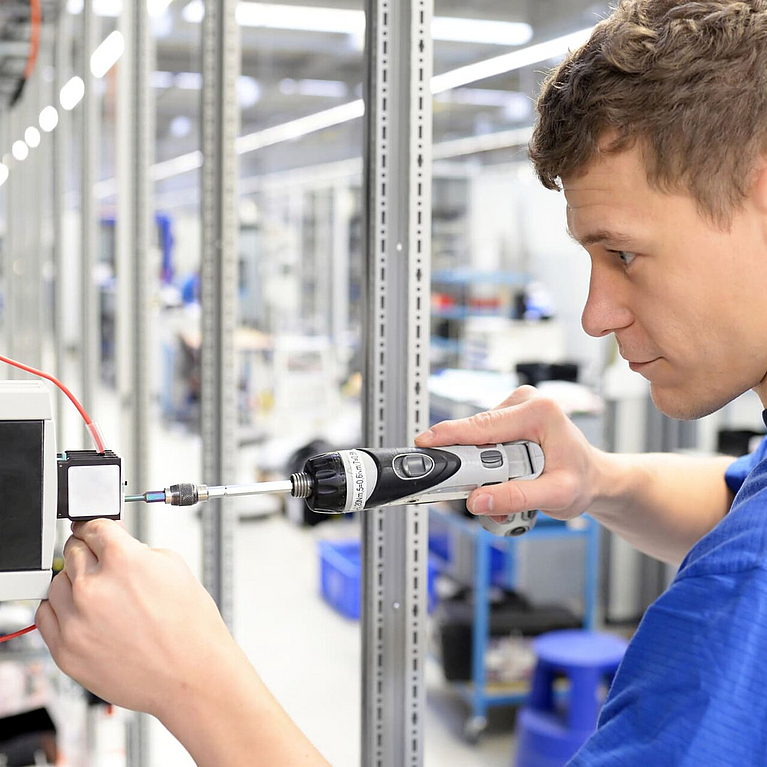 Junger Mann arbeitet in einer Produktionshalle