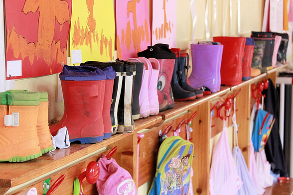 Kindergummistiefel aufgereiht im Kindergarten