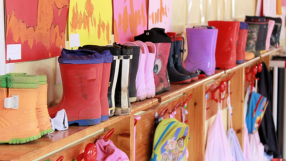 © marcobir - istock.com  Kindergummistiefel aufgereiht im Kindergarten