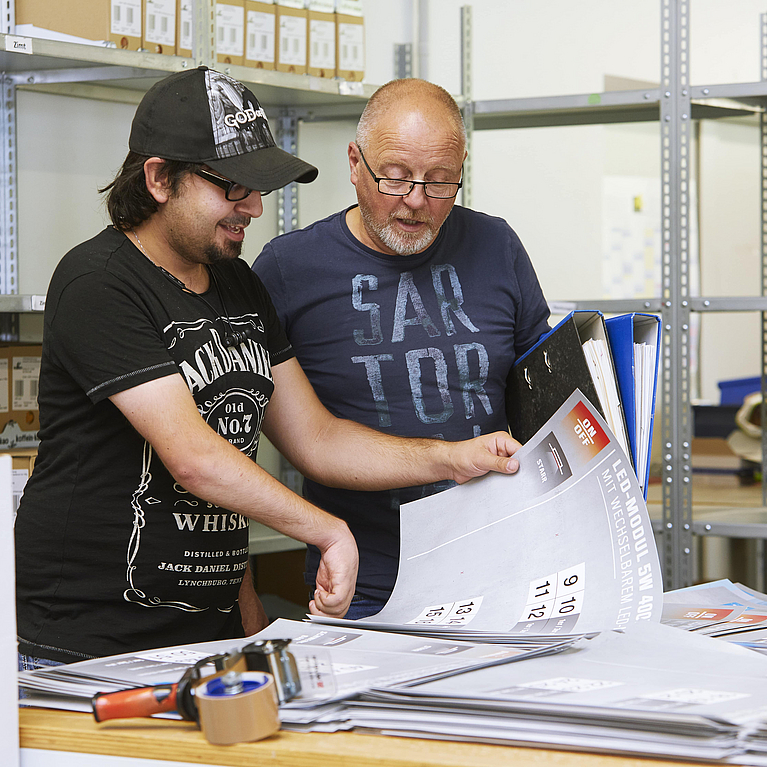 Zwei Kollegen arbeiten an einem Printprodukt