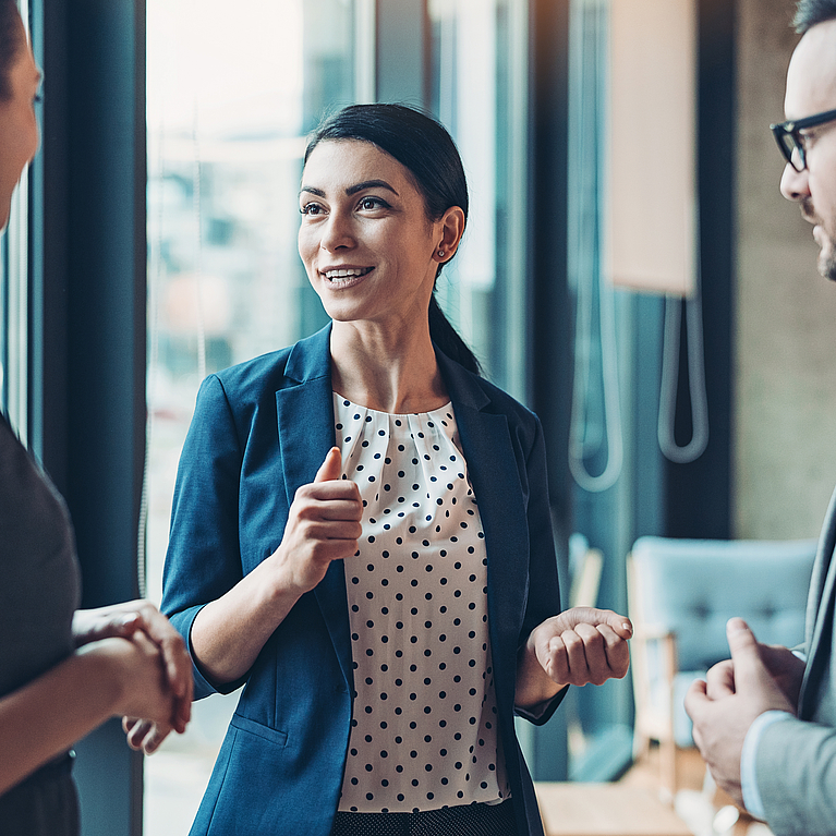 Junge Führungskraft spricht mit Mitarbeitenden