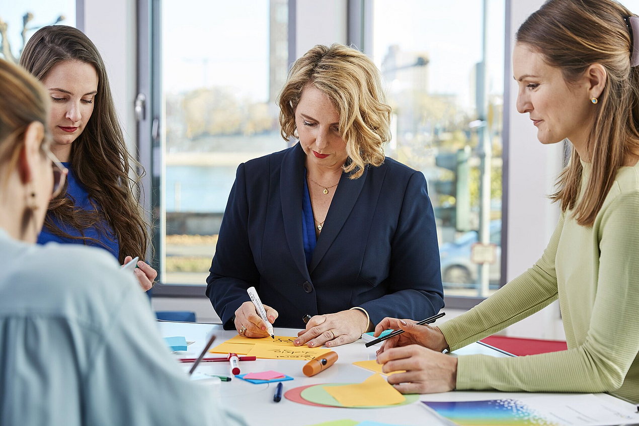 Das KOFA-Team bereitet einen Workshop vor und beschriftet Karteikarten.