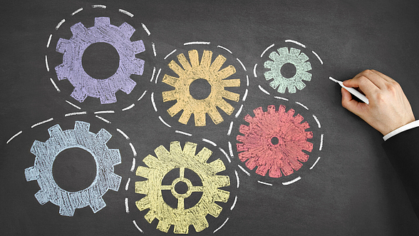© Anilakkus – istock.com  Unterschiedliche Zahnräder, mehrfarbig