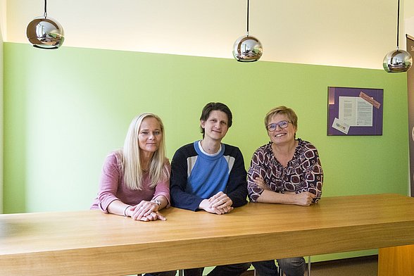 Drei Mitarbeiter der ise GmbH sitzen am Tisch