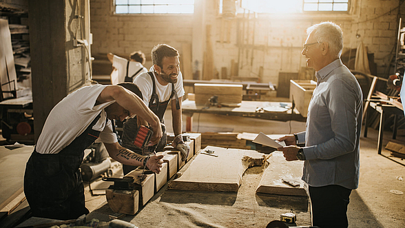 Kollegen unterhalten sich in einer Werkshalle 